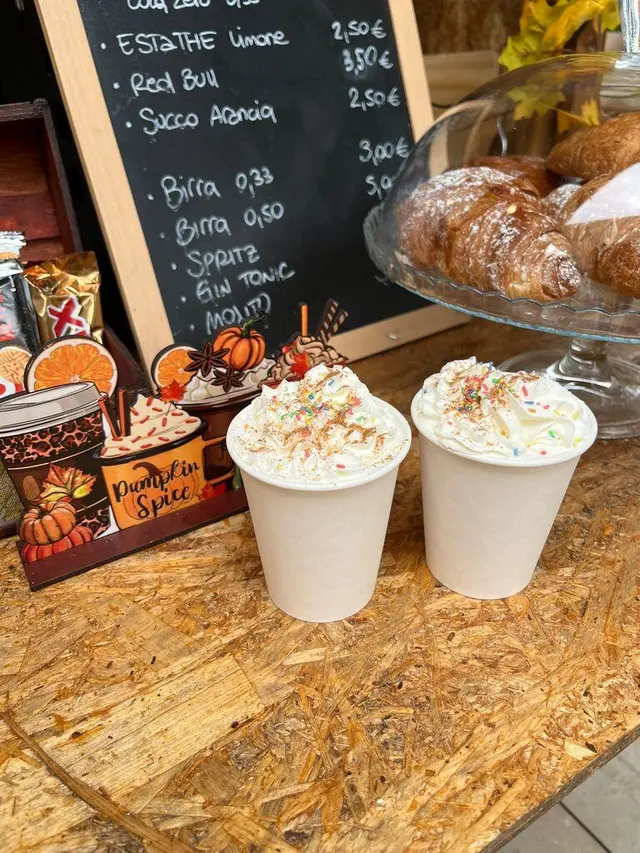 Due bicchieri di pumpkin spice con panna montata sul bancone del punto ristoro